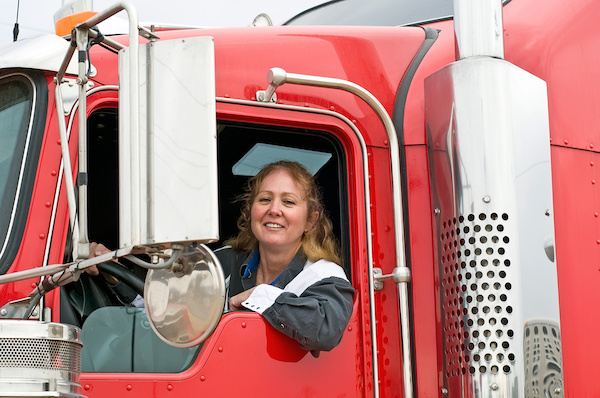 Woman truck driver leaning out the drivers side window.